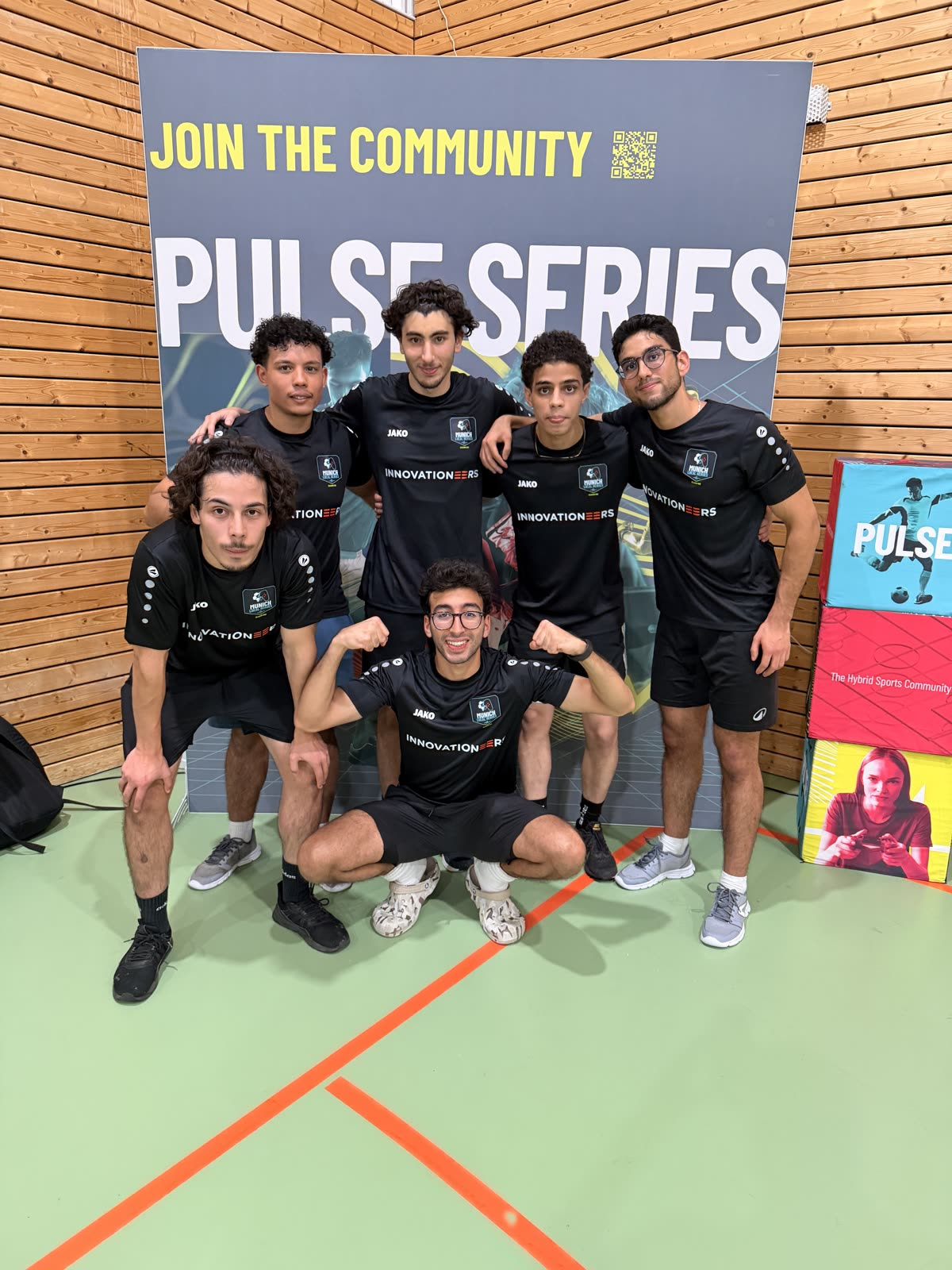 Spieltag-Team in Trikots vor der PULSE-Wand